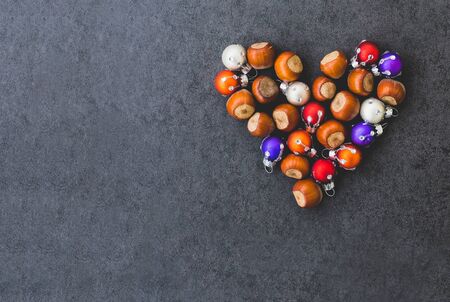 The heart of the hazelnuts and christmas decorations in grey backgroundの写真素材
