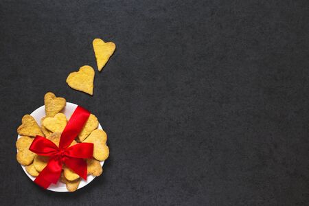 Cookies tied with a bow of red ribbon on stone backgroundの写真素材