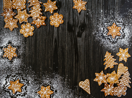 Christmas gingerbread with snowflakes decorations on dark wooden backgroundの写真素材