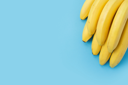 Banana bunch in corner on blue backgroundの写真素材