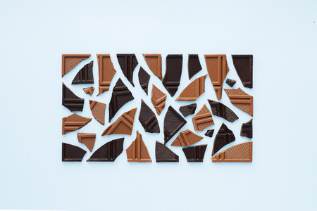 Mixed dark and milk chocolate in rectangle on blue background. Top viewの写真素材