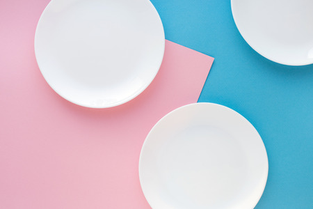 Three white plates on color background. Abstract, top view.の写真素材