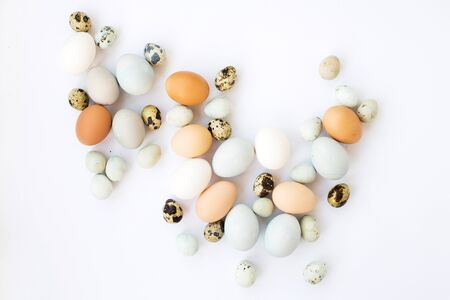 Chicken and quail eggs on a white background. Top view