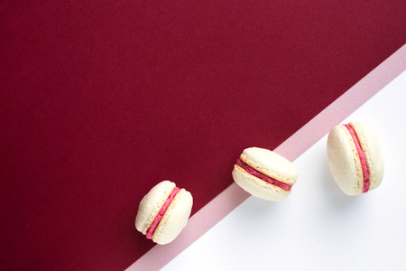 Three macaroons on red and white backgroundの写真素材