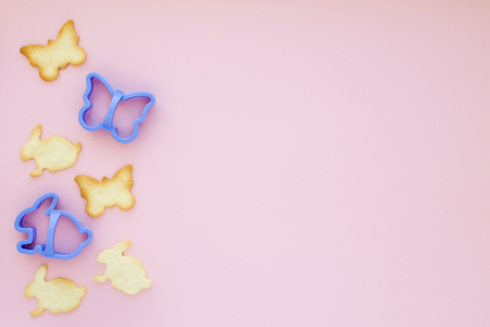 Easter biscuits with blue plastic forms on pink backgroundの写真素材