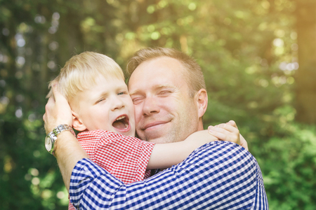Son and father in gentle embrace.の写真素材