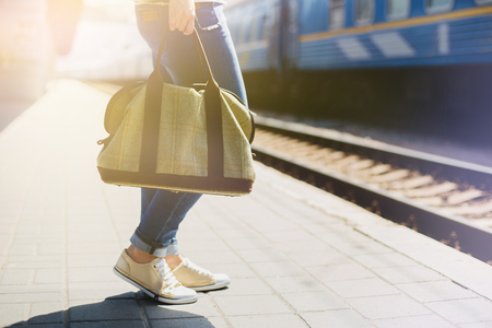 Woman holding a bag at a train stationの写真素材