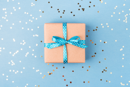 Gift box wrapped in kraft paper with confetti.の写真素材