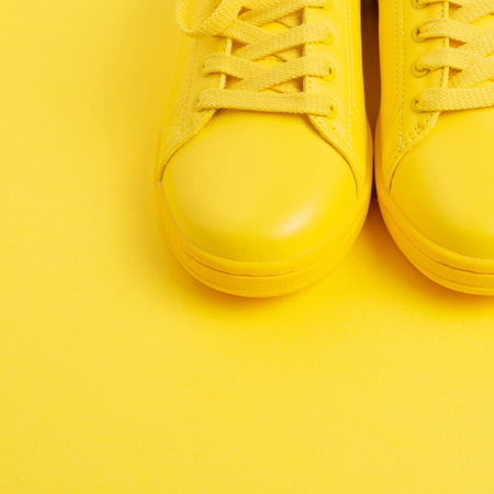 Pair of yellow shoes on yellow background.の写真素材