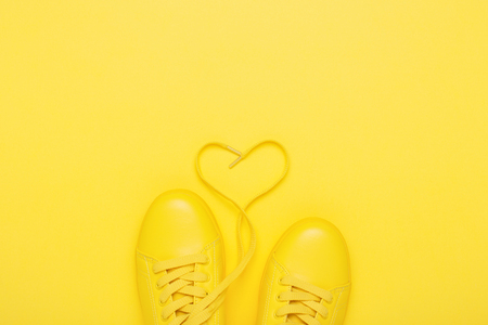 Pair of yellow shoes on yellow background.の写真素材
