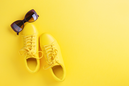 One pair of yellow shoes on yellow background.の写真素材