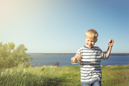 Blond boy joyful and smiling on nature.の写真素材