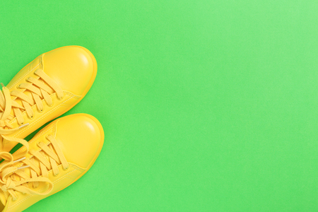 Pair of yellow shoes on green background.の写真素材