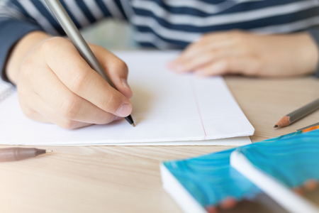 Kid writing in notebook.の写真素材