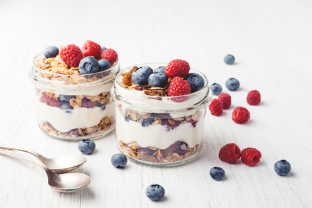 Granola with berries and yogurt in jars.の写真素材