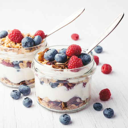 Granola with berries and yogurt in jars.の写真素材