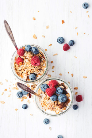Granola with berries and yogurt in jars.の写真素材