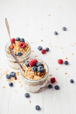 Granola with berries and yogurt in jars.の写真素材