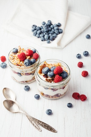 Granola with berries and yogurt in jars.の写真素材
