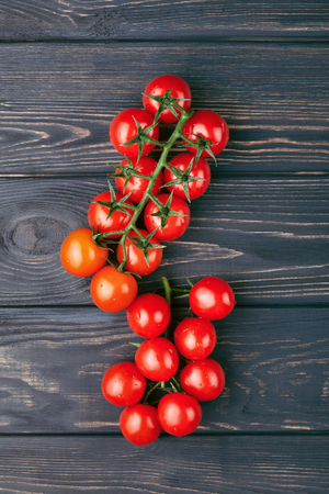 Bunch of fresh cherry romatoes on dark wooden background. Top view.の写真素材