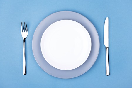 Empty plate with fork and knife. Setting table, top view.の写真素材