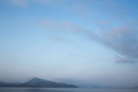 Sunrise in bay of sea. Morning haze, beautiful view on mountains and sea.の写真素材