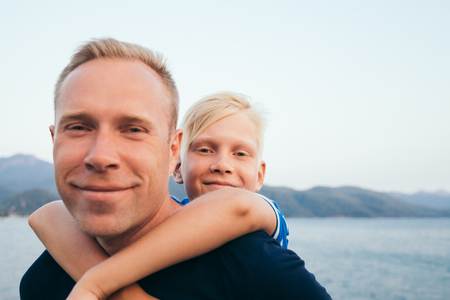 Father and son together. Son hugging father. Summer vacation.の写真素材