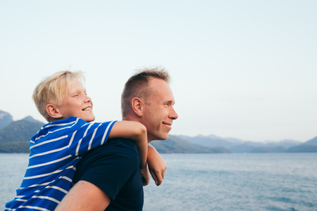Father and son together. Son hugging father. Summer vacation. Selective focus.の写真素材