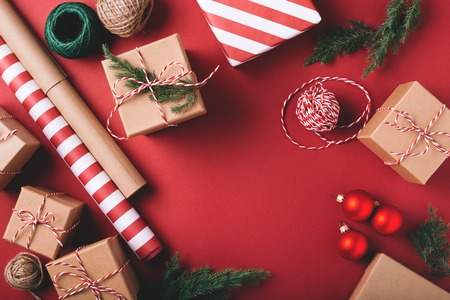 Christmas background with gifts and decorations on red. Preparation for holidays. Top view with copy space.の写真素材