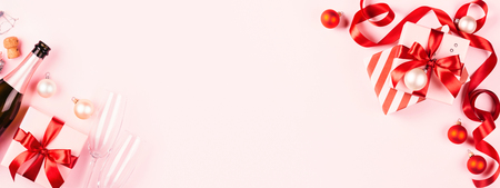 Christmas gifts with red ribbon, champagne Beautiful holiday composition. Banner with copy space.の写真素材