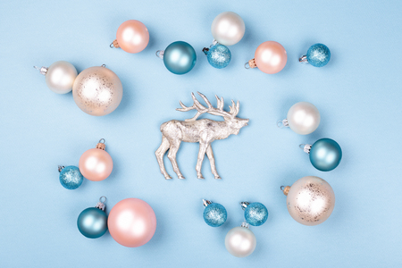 Frame of Christmas balls with figurine of reindeer on blue background. Minimal styled holiday card.の写真素材