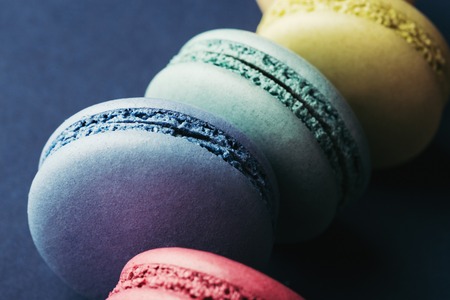 Colorful macarons on dark blue background. Top view, close up.の写真素材