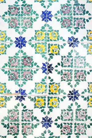 Traditional ornate portuguese decorative tiles azulejos in white, yellow, green and blue colours.