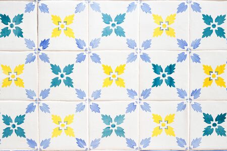 Traditional ornate portuguese decorative tiles azulejos in white, yellow, green and blue colours.