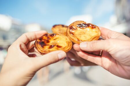 Traditional portuguese desserts in womans hands. Pastel de Nata.の写真素材