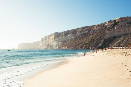 Ocean coastline with waves, people and cape. Summer background.の写真素材