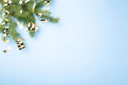 Blue Christmas background with fir branches, golden serpentine and confetti with copy space for text.の写真素材