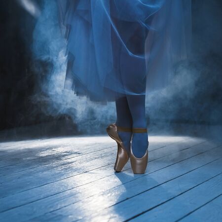 The feet of balerina in the blue smoke. Ballet position.の写真素材