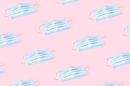 Pattern made of blue medical masks on pink background. Protection against virus concept.の写真素材