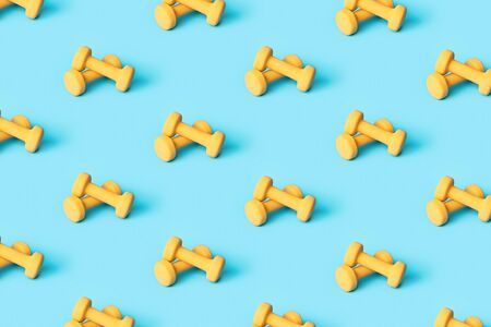 Pattern made of yellow dumbbells on blue background. Sporty and activity concept.の写真素材