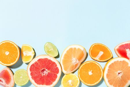 Border made of mix of citrus fruits on blue background.の写真素材