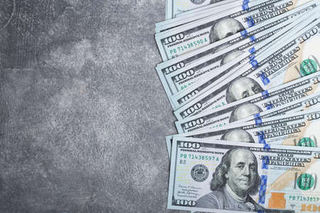 American dollar bills on grey stone background. Top view with copy space.