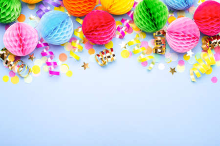 Birthday party background on violet. Top view. Border made of colorful serpentine, balls and confetti.の写真素材