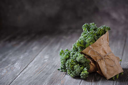 Two bunch of broccolini on wooden table. Angle view with copy space.の写真素材