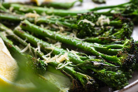 Roasted broccolini with lemon on the plate . Close up angle view.の写真素材