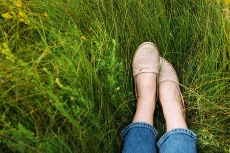 Womans feet lying on grass. Summer resting.の写真素材