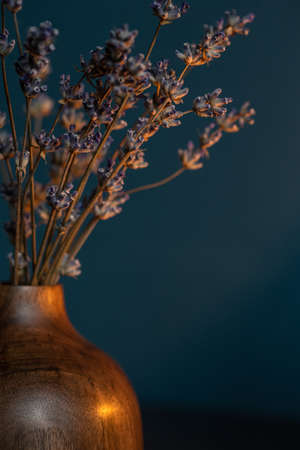 Dried lavender in wooden vase on dark blue background with copy space.の写真素材