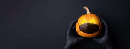 Black banner with Halloween pumpkin in medical mask. Lockdown concept.の写真素材