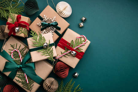 Many Christmas gift boxes tied velvet ribbons with paper decorations on turquoise background. Holiday background in earth colours.の写真素材