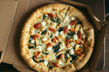 Pizza in box on the table. Top view.の写真素材